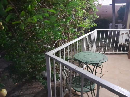 una mesa y sillas sentadas en un balcón en Musgrave AnneX- comfy 1 bedroom apartment on the ground floor, en Kingston
