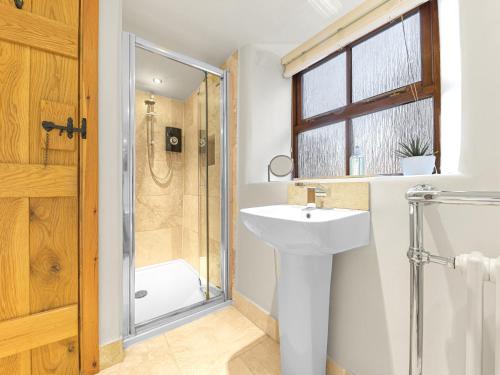 uma casa de banho com um lavatório e um chuveiro em Swallow Barn em Cockermouth