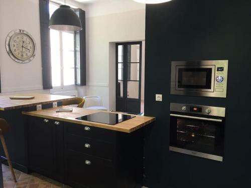 une cuisine avec un évier et un micro-ondes dans l'établissement Le Félix- ancien hôtel particulier dans l’hyper centre, à Avignon