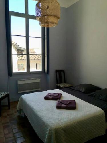une chambre avec un lit avec deux serviettes dessus dans l'établissement Le Félix- ancien hôtel particulier dans l’hyper centre, à Avignon