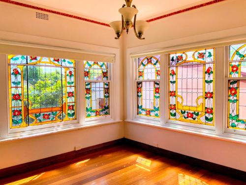 an empty room with stained glass windows at Handcrafted stained-glass cottage, free parking in Hobart