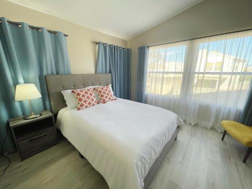 1 dormitorio con 1 cama y una ventana con cortinas azules en Pool House Newly Remodeled 3bed 3bath Near DT Summerlin and Red Rock, en Las Vegas
