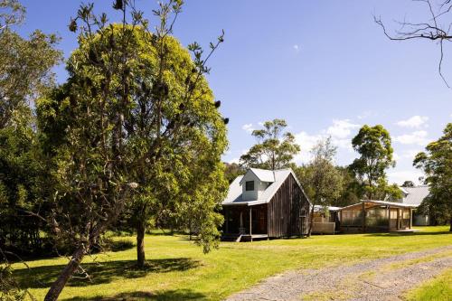 a barn with a tree and a house at THE MAINSTAY FARMSTAY Unique Aussie Farmstay, Seal Rocks, Barrington Coast in Neranie