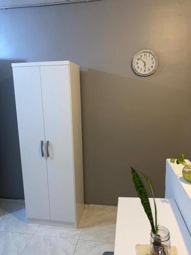 une chambre avec une armoire et une horloge sur le mur dans l'établissement Cuarto privado con entrada independiente cerca al Poblado, à Medellín