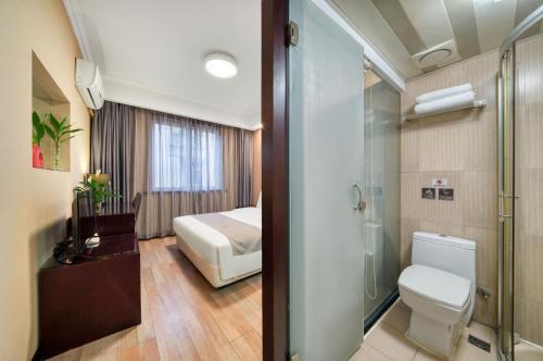 uma casa de banho com um WC, uma cama e um chuveiro em Hangzhou Bokai Westlake Hotel em Hangzhou