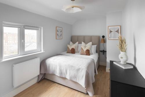 a white bedroom with a bed and a window at Urban Rest Merrion Square Apartments in Dublin
