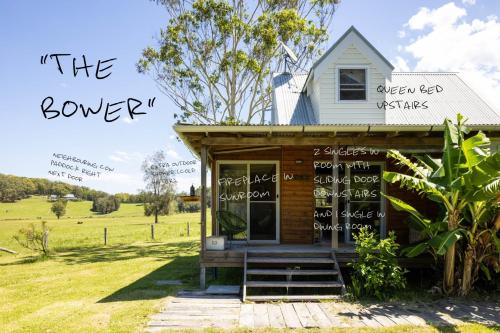 a tiny house with a sign that reads theower at THE MAINSTAY Farmstay - book one of 4 houses or all 4, minutes to Seal Rocks! in Neranie