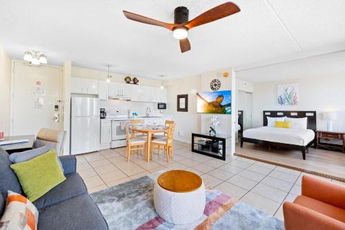 a living room with a couch and a dining room at Cozy & City View Steps to Waikiki Beach with Parking in Honolulu