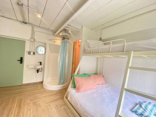 a room with two bunk beds and a bathroom at The Greens Old Town Bangkok in Bangkok