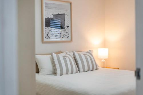 a bedroom with a white bed with white pillows at Poppy's Place - oceanstays in Yamba