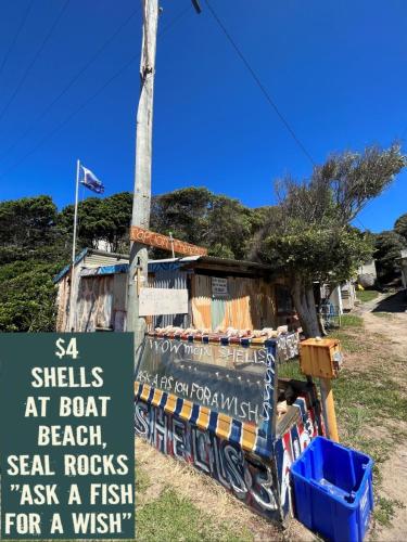 a sign in front of a fish stand with a pole at THE MAINSTAY Farmstay - book one of 4 houses or all 4, minutes to Seal Rocks! in Neranie