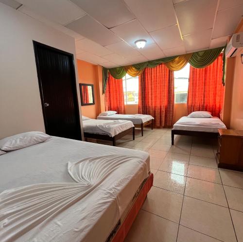 um quarto de hotel com duas camas e uma janela em CASA DE HOSPEDAJE PEDERNALES em Pedernales
