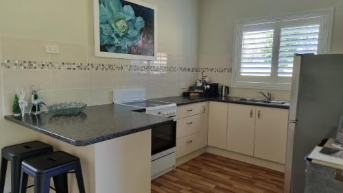 a kitchen with a counter and a sink and a refrigerator at Little Britton in Wingham
