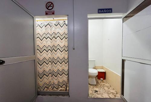 a bathroom with a door with a toilet in it at CASA DE HOSPEDAJE PEDERNALES in Pedernales