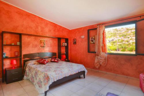 a bedroom with orange walls and a bed with a window at Holiday Home Floridia - ISI02100b-O in Floridia