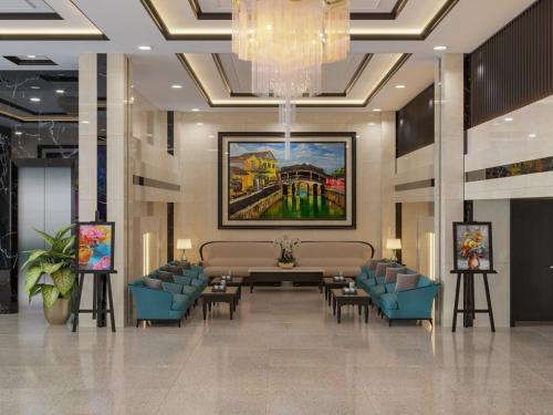 a lobby with a table and chairs and a painting at ViAn Hotel And Spa Danang in Danang