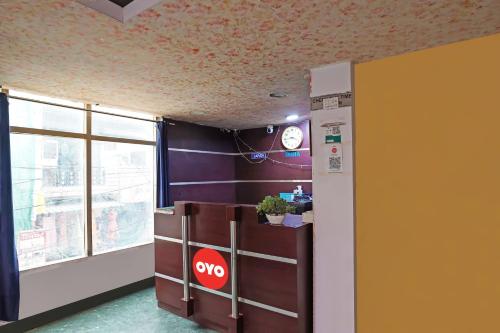 una oficina con un reloj en la pared y un mostrador en OYO Flagship Mohan Residency, en Indirapuram