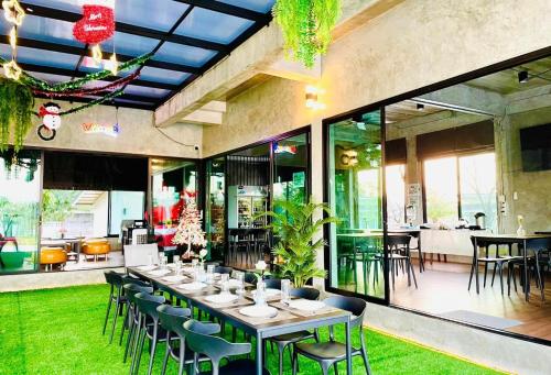 a dining room with a long table and chairs at Farm View Resort @Uthai Thani ฟาร์มวิว รีสอร์ท อุทัยธานี in Nong Khayang