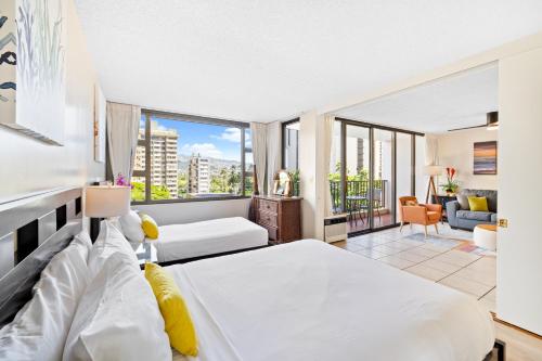 a bedroom with two beds and a living room at Cozy Waikiki Getaway, Stroll to Beach with Free Parking in Honolulu