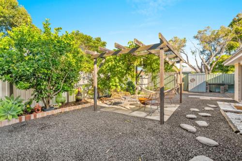 a playground in a backyard with a wooden pergola at Callala Beach Walk - Beachfront with Fireplace in Callala Beach