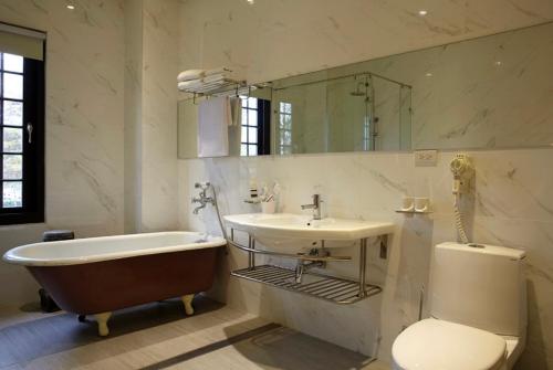 bagno con vasca, lavandino e servizi igienici di Holiu Resort a Nan-p'ing-li