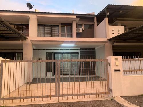 a house with a gate in front of it at Juwita&Arjuna Homestay Teluk Senangin in Kampong Batu Tiga