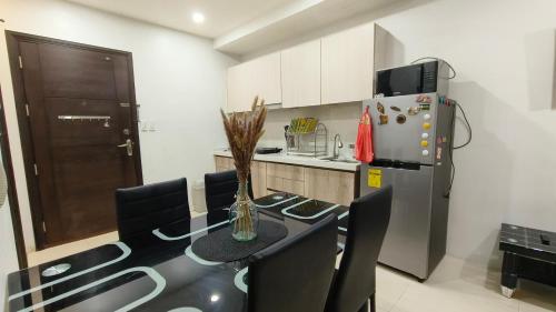 a kitchen with a table with chairs and a refrigerator at GF-16 Megatower Residences 2 in Baguio