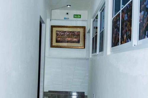 a hallway with white walls and a picture on the wall at Marvelz Hotel 