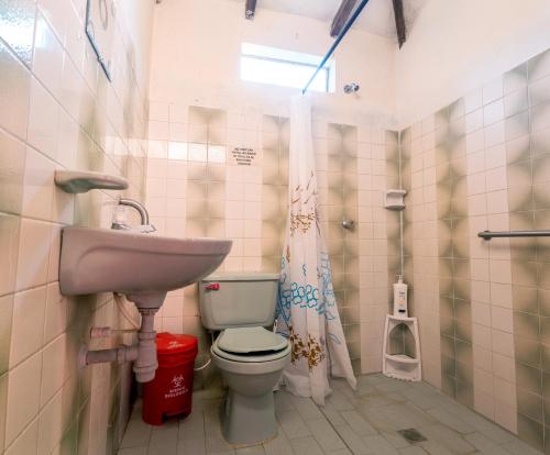 a bathroom with a toilet and a sink at Casa Finca Genesis in Buga