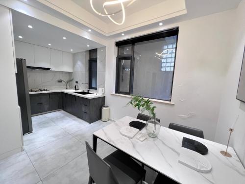 a kitchen with a white table and chairs in a room at Shanghai World Expo Villa B&B - Near Lujiazui in Shanghai