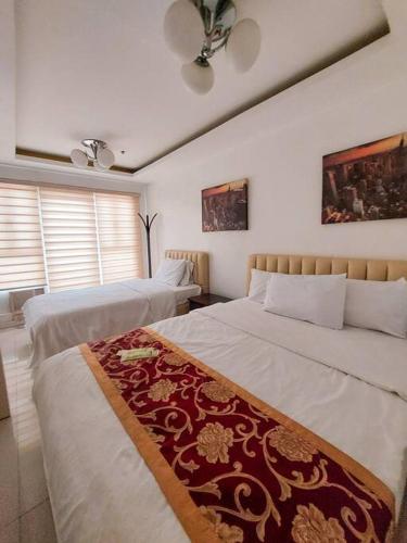1 dormitorio con 2 camas y ventilador de techo en Budget Family Room w FREE pool access in Manila, en Manila