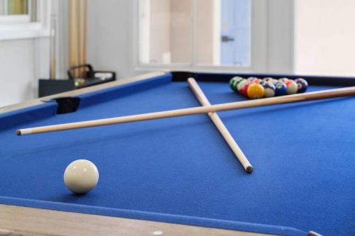 two cue sticks and balls on a pool table at Gamers Getaway: Arcade, Theater, Racing, And More! in Stanton