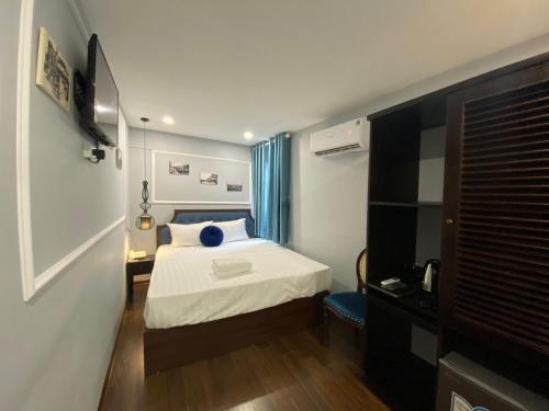 a bedroom with a bed with a blue pillow on it at La Renta Hotel & Spa in Hanoi