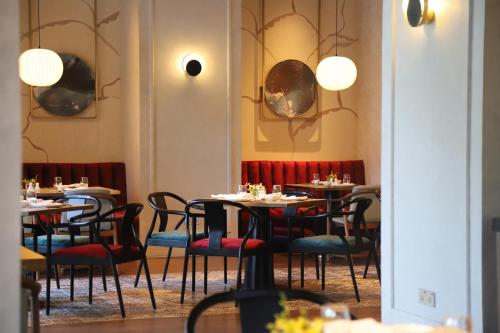 a dining room with tables and chairs and lights at Melia Hanoi in Hanoi