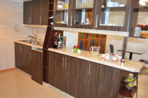 una cocina con armarios de madera y fregadero en Hotel Boutique Amalfi, en Iquique