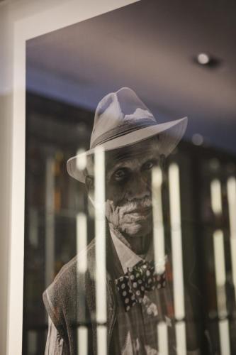 a man in a hat behind a glass window at The Laslett in London