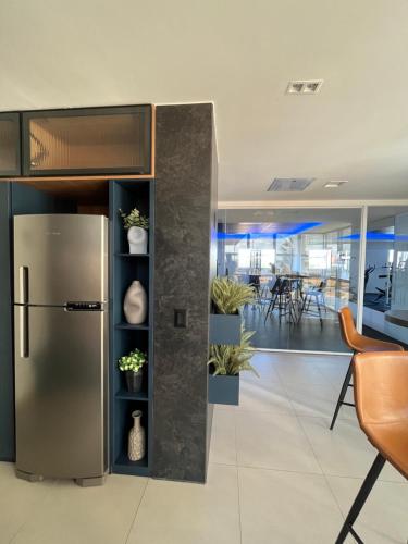 einem Kühlschrank aus rostfreiem Stahl in einem Büro mit Pflanzen in der Unterkunft Studio Estilo Industrial +Espaço in Mossoró