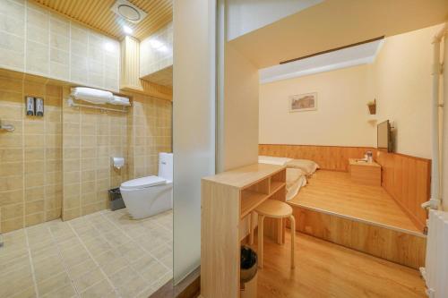 a bathroom with a toilet and a sink and a tub at Harbin Hash International Youth Hostel Harbin West Station in Harbin