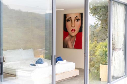 a bedroom with a painting of a woman on the wall at Serenity and Modern Art - Open Hill View 3BR Natural Park Villa 1 in Kamala Beach