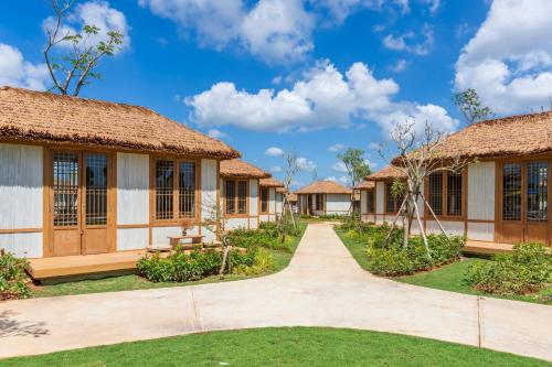 a row of cottages with a pathway in front at K-Town Resort Phan Thiet in Phan Thiet
