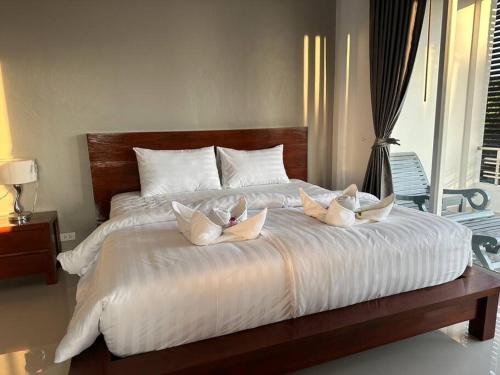 a large white bed with three pillows on it at 2 Bedroom Seaview Apartment Lanta Sport Resort 305 in Phra Ae beach