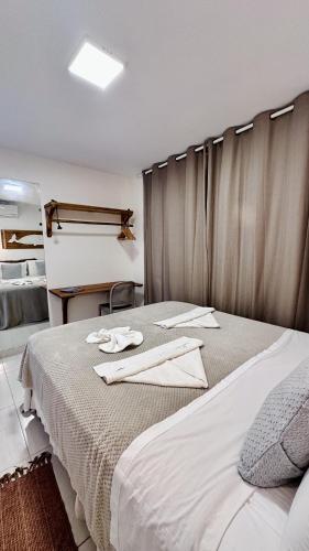 a bedroom with a bed with towels on it at Apê Jardins in Flecheiras