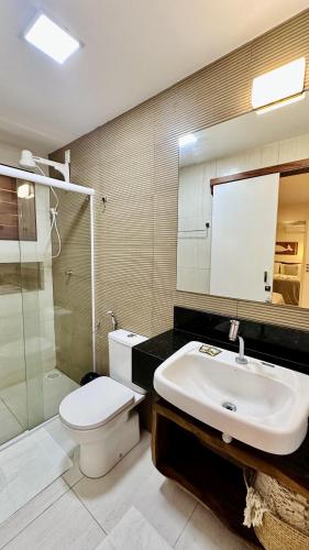 a bathroom with a toilet and a sink and a shower at Apê Jardins in Flecheiras
