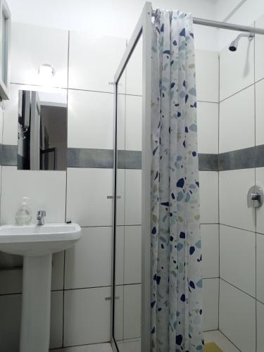 a bathroom with a sink and a shower curtain at Apartamento con Jardín Privado en Tarija - Precio al Cambio Oficial in Tarija