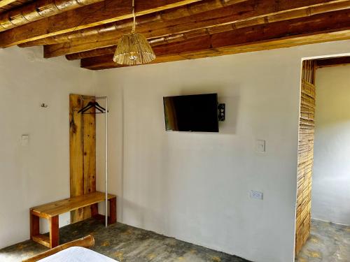 a living room with a tv on a wall at Finca el Manantial Isnos in Isnos