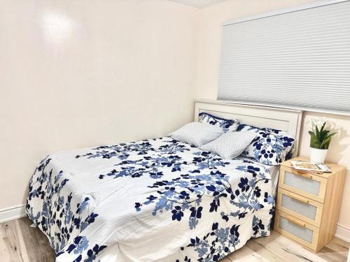 ein Schlafzimmer mit einem Bett mit blauen Blumen darauf in der Unterkunft Bedroom 1 with free Parking, free wi-fi and shared washroom (Room 1) in Kitchener