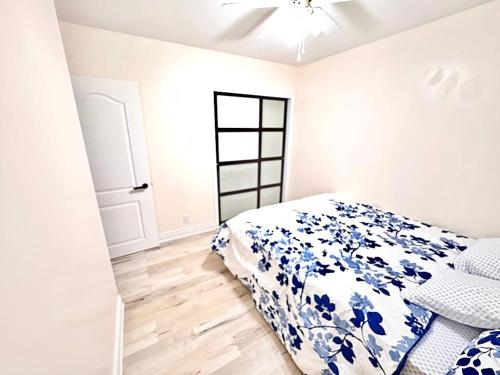 um quarto com uma cama com um edredão azul e branco em Bedroom 1 with free Parking, free wi-fi and shared washroom (Room 1) em Kitchener
