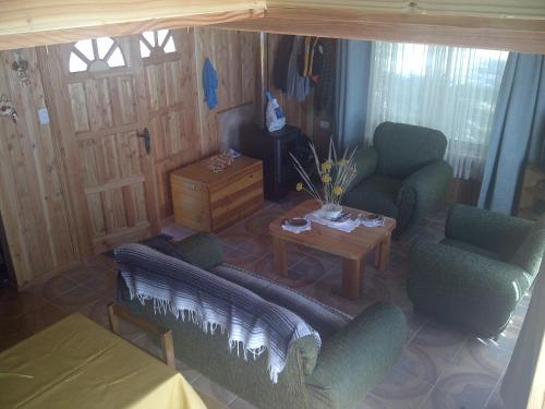 a living room with two chairs and a table at Casa en Choshuenco a 180 metros de la Playa, Panguipulli, Los Ríos in Panguipulli