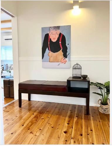 a bench in a room with a painting on the wall at ハルク キャビン in Nakijin