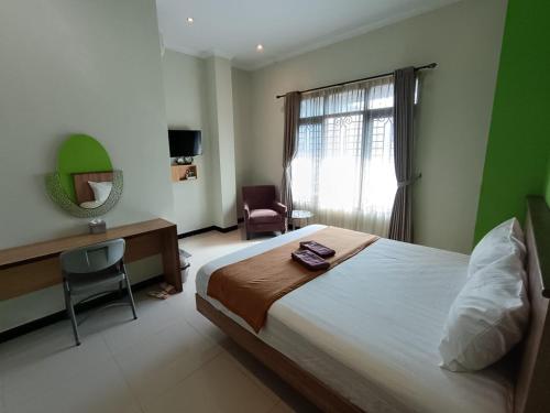 a bedroom with a bed and a desk and a window at The Cabin Hotel Ngupasan in Yogyakarta
